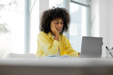 Tired african american female student is sad at the computer, preparing for a difficult exam, work. High quality photo