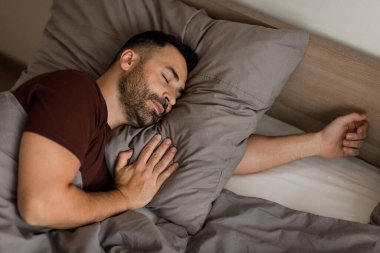 Yakışıklı sakallı adamın evde uyuduğu, iyi uykuların, üst manzaranın, fotokopi alanının tadını çıkardığı yakın plan. Yüksek kalite fotoğraf