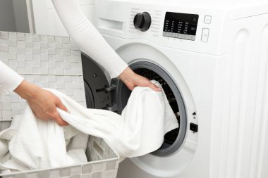 Kız evde çamaşır yıkıyor, çamaşır makinesine çamaşır yüklüyor ve ev işlerini yapıyor. Yüksek kalite fotoğraf