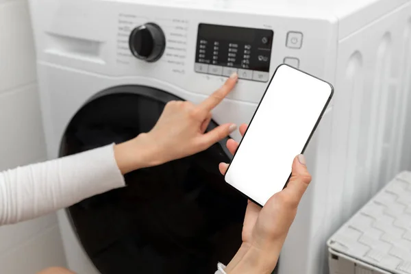 Seorang Wanita Dimuat Mesin Cuci Dengan Cucian Kotor Menggunakan Smartphone — Stok Foto