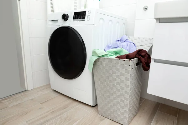Bathroom interior washing machine with laundry basket full to the top. High quality photo