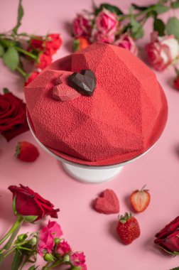 Kalp şeklinde pasta, kırmızı ve pembe güllerle süslenmiş. Kalp şeklinde kremalı pasta. Velor kapağı. Ev yapımı pastane. Sevgililer Günü hediyesi..