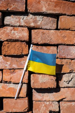 Kırmızı tuğlalı arka planda Ukrayna bayrağı.
