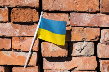 Kırmızı tuğlalı arka planda Ukrayna bayrağı.