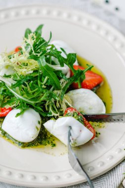 Hafif yaz salatası. Çilekli bufalo mozzarella, pesto, roka ve marul. Yakından çatal ve bıçakla salata tadıyorum.