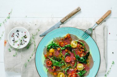 Vierge soslu ton balığı carpaccio. Vişneli domates ve roka ile servis edilir. Taze İtalyan mezesi. İtalyan Akdeniz mutfağı ve deniz ürünleri.