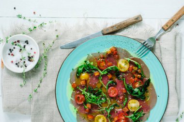 Vierge soslu ton balığı carpaccio. Vişneli domates ve roka ile servis edilir. Taze İtalyan mezesi. İtalyan Akdeniz mutfağı ve deniz ürünleri.