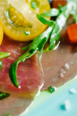 Vierge soslu ton balığı carpaccio. Vişneli domates ve roka ile servis edilir. Taze İtalyan mezesi. Deniz mahsullü İtalyan Akdeniz mutfağı. Makro çekim