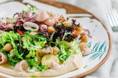 Nohut salatası, bebek kalamar, bebek ahtapot, kiraz domatesleri, marul, roka ve humus. Korsika adasından İtalyan-Fransız yemeği.