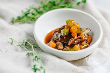 Haşlanmış sebzeli ve küp küp kesilmiş bir et parçası. Kabak, kabak ve patates. Küçük beyaz bir kasede atıştırmalık. Boşluğu kopyala.