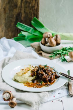 Mantarlı haşlanmış domuz eti ve patates püresi. Restoran servisi.