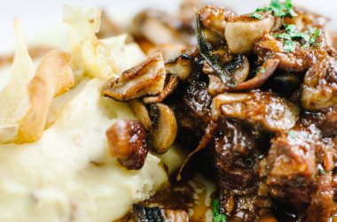 Mantarlı haşlanmış domuz eti ve patates püresi. Restoran servisi.