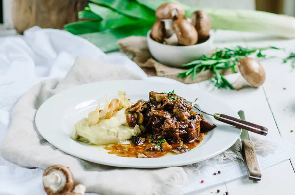 Mantarlı haşlanmış domuz eti ve patates püresi. Restoran servisi.