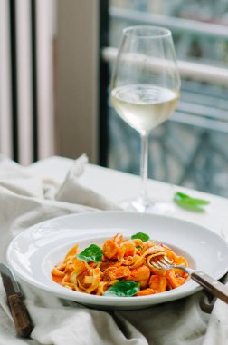 Domates, fesleğen ve parmesanlı geleneksel İtalyan makarnası. Bir restoranda yemek.