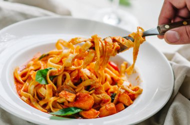 Domates, fesleğen ve parmesanlı geleneksel İtalyan makarnası. Tabak tatma