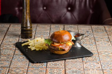 Meyhanede ya da restoranda siyah bir tahta üzerinde domuz pastırması ve trüf yağı ile ağız sulandıran burger..