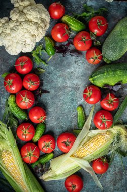 Fresh vegetables on a dark green background. Tomatoes, cucumbers, eggplants, cauliflower and corn. Harvest/gardening concept. Healthy food. Vegetarianism. Clean nutrition. Place for text. Making salad ingredients