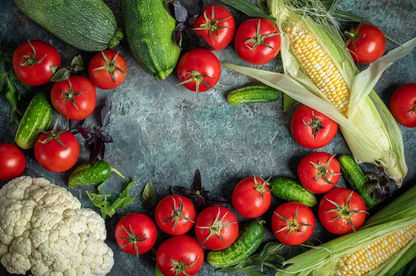 Fresh vegetables on a dark green background. Tomatoes, cucumbers, eggplants, cauliflower and corn. Harvest/gardening concept. Healthy food. Vegetarianism. Clean nutrition. Place for text. Making salad ingredients