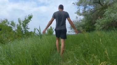 Uzun otların arasında yürüyen adam SlowMo