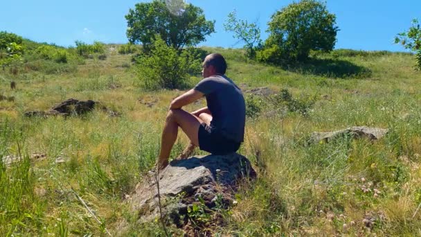 坐在岩石上的人 — 图库视频影像