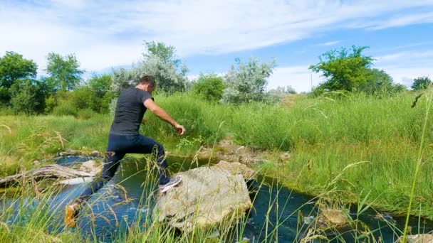 Bir Adam Nehrin Karşısındaki Taşlara Atlıyor Yavaş Çekim — Stok video