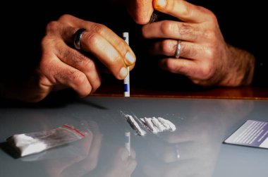 Bu Kafkasyalı adam kokain çekiyor, daha önce bantlara sarılmış bir banknotla zorla girilmiş. Uyuşturucu bağımlılığı sorunları. Yüksek kalite fotoğraf