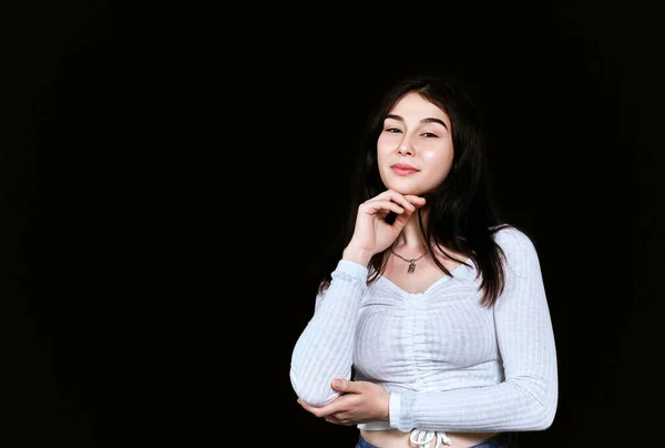 Beyaz bluzlu güzel bir kadın siyah arka planda yüzünde tatmin edici duygularla kameraya bakarken çenesini eline dayayıp dinleniyor. Fotokopi alanı olan pankart. Doğal güzellik, saç bakımı, açık ten..