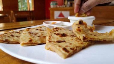 Popüler Hint yemeklerini yerken çekilmiş makro görüntüler aloo paratha / patates doldurulmuş yoğurt, turşu ve yeşil turşu ile servis edilen düz ekmek