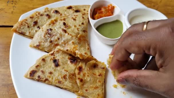 人気のインド料理のトップビューもパラタ ポテト詰めフラットパンヨーグルト 緑のチャツネを提供しています — ストック動画