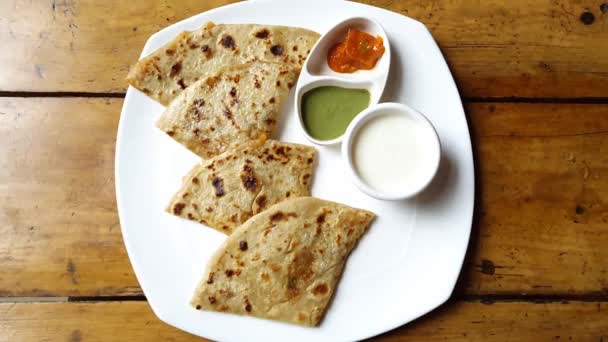ヨーグルト 緑のチャツネを添えた人気のインド料理もパラタやポテト詰めのフラットブレッドを食べるの終わり — ストック動画