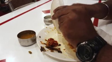 Man serving chicken biriyani into his plate. The most popular Indian cuisine chicken is prepared using rice, chicken and tasty spices.