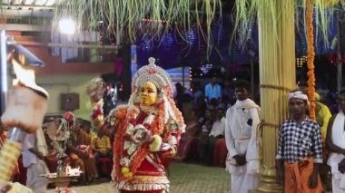 Udupi, Hindistan - 7 Mart 2020: Hindu dini etkinliği sırasında toplanmış bir tapınağın içinde eşsiz bir kostümle dans eden sanatçı, Bhootha Kola dans festivali Bhootha Kola, Karnataka kıyılarında ruha tapan bir Hindu ritüelidir.