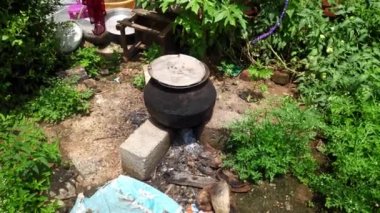 Hindistan 'da yaz aylarında büyük çatal bıçak ve odun ateşiyle suyu ısıtmanın eski bir yolu.