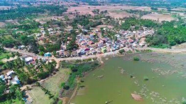 Hindistan 'da yaz aylarında büyük göl kenarındaki küçük köyün havadan görünüşü.