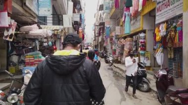 Bangalore, Hindistan-14 Ağustos 2020: Bangalore 'da yazın işlek bir alışveriş caddesinde yürüyen bir adamın yavaş çekim videosu