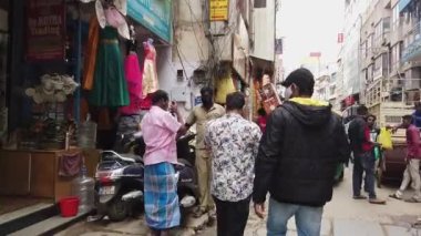 Bangalore, Hindistan-14 Ağustos 2020: Bangalore 'un küçük işlek alışveriş caddesinde yürüyen iki adamın arka görüntüsü