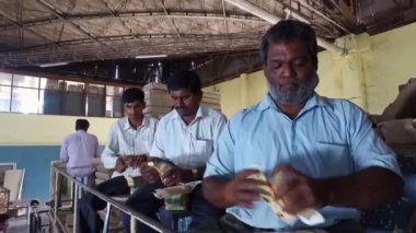 Bangalore, Hindistan-5 Nisan 2016: Sabun kutularını sürekli ve hızlı yapan işçiler, sabun / ambalaj / ambalaj ve tasnif işleriyle uğraşıyorlar