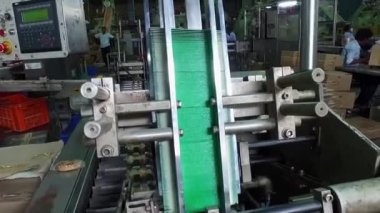 Bangalore, Hindistan-5 Nisan 2016: Sabun / konveyör makinesinin paketlenmesi / üretimi için sabun ve kutuların birlikte taşındığı taşıyıcı bant