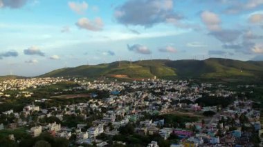 Chitradurga, Hindistan-10 Ekim 2022: Hava meyili bulutlu bir gökyüzü altında dağlarla çevrili güzel bir şehrin görüntüsünü ortaya çıkardı.
