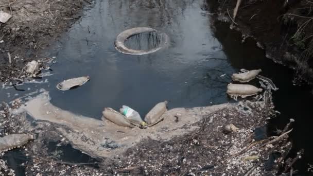 Inquinamento ambientale. Bottiglie di plastica, borse, pneumatici, rifiuti nel fiume — Video Stock