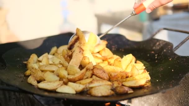 Жареная картошка. Молодой картофель жарят на сковороде. Поджаренная хрустящая корочка — стоковое видео
