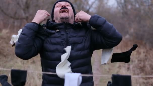 Uomo felice con i baffi finti lancia calzini per strada — Video Stock
