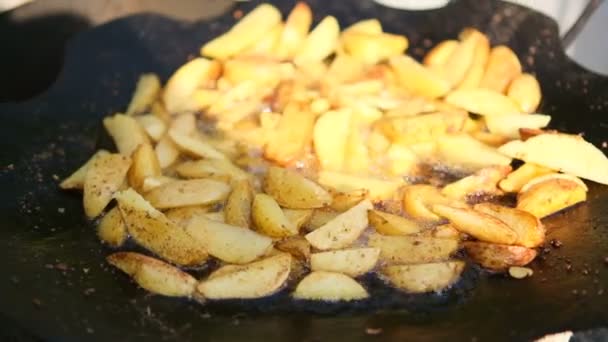 Жареная картошка. Молодой картофель жарят на сковороде. Поджаренная хрустящая корочка — стоковое видео