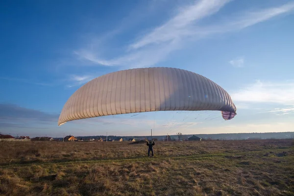Paraşütlü adam parkta tek başına çalışıyor..