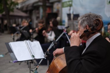 Zhytomyr, Ukraine - May 15, 2021: man street musician playing cello classical music.