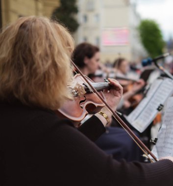 woman street musician playing violin classical music.