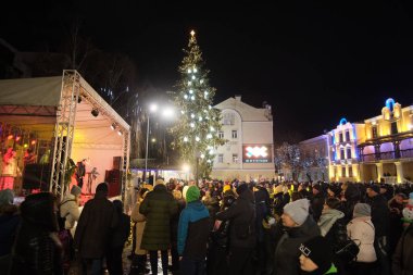 Zhytomyr, Ukrayna - 19 Aralık 2021: İnsanlar yeni yılı kutlamak için gece toplandı. Arka planda Noel ağacı