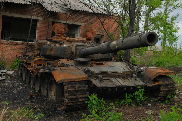 Русский боевой танк, который был уничтожен во дворе села во время российской агрессии. Русский танк прятался во дворе украинской деревни.