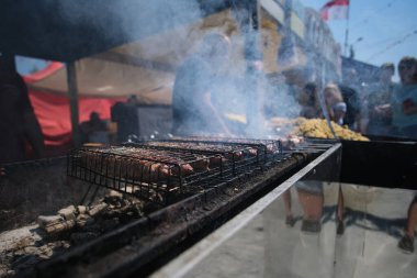 Kızarmış etli biftek, baharat ve otlarla birlikte, yanan kömürlerin içinde, bbq ızgarası, alevler ve duman. Izgara çizgili sulu biftek piknik kutlaması için hazır. Barbekü ızgarası