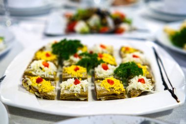 Beyaz tabakta peynirli ve domatesli ciğer keki..